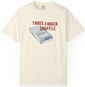 Beige t-shirt with a cassette tape graphic and 'Three Finger Shuffle' text on a white background
