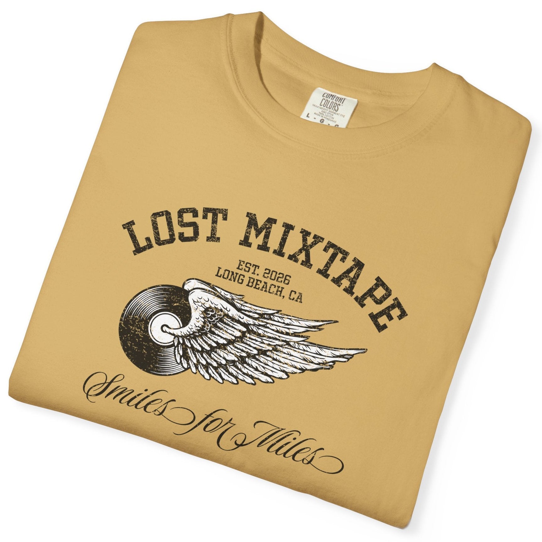 Folded tan t-shirt with 'Lost Mixtape' design on a white background