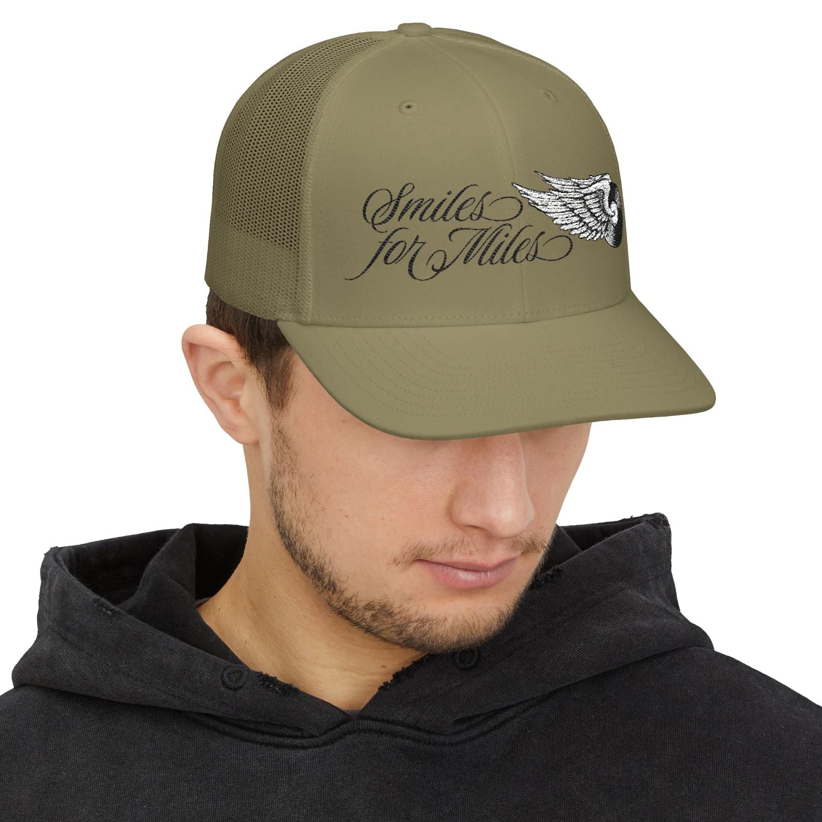 Man wearing a green cap with text and logo on a white background