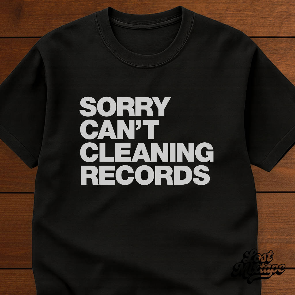 Black t-shirt with white text 'SORRY CAN'T CLEANING RECORDS' on a wooden surface